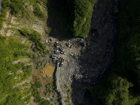Aerial view of Tambang Pasir Merapi Kali Gendol Sand Mine with excavators and trucks operating in a rocky valley Kecamatan Cangkringan, Daerah Istimewa Yogya, Indonesia.