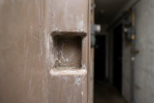 Close-up of gas meter box latch indent with UV degradation and dust