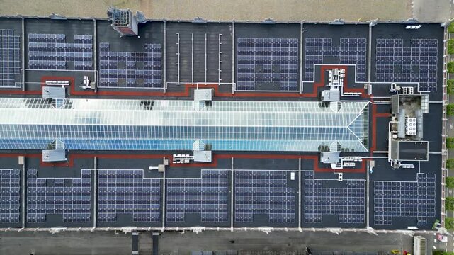 Aerial view of solar panels and a glass skylight on a large building roof Brussels, Brussels, Belgium.