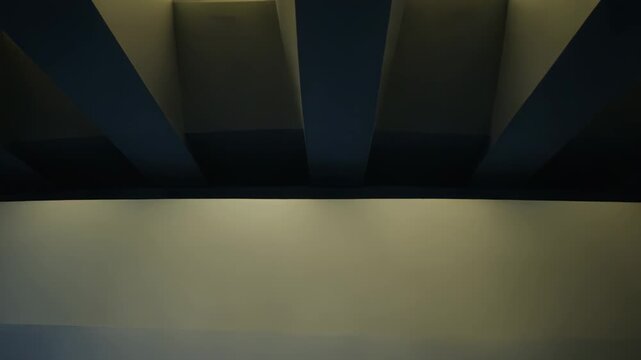 Futuristic architectural ceiling with white and blue beams, sharp leading lines and strong light shadow contrast forming an abstract, minimalist geometric perspective background