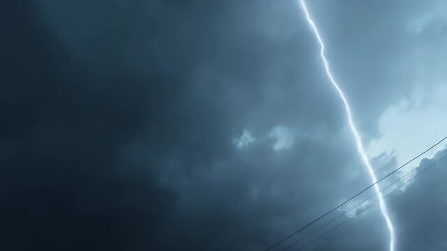 Dark storm clouds fill the sky, creating a gloomy and atmospheric scene with power lines adding to the urban weather landscape during an impending storm