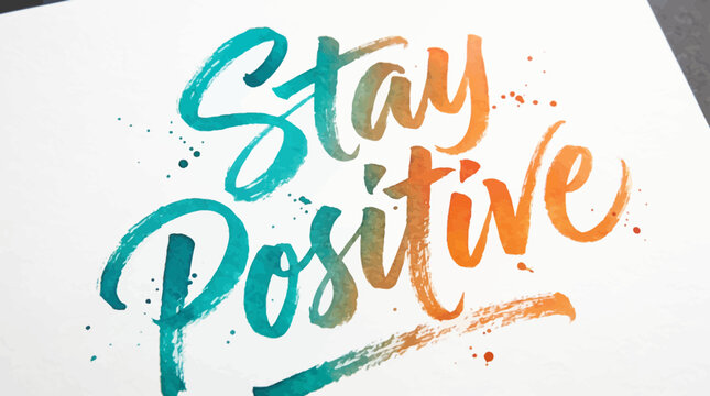 Calligraphy of the words Stay Positive in a teal to orange watercolor gradient on textured white paper