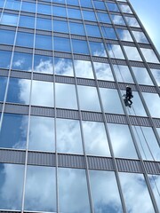 Obraz premium Window Cleaner Working on High Rise Building