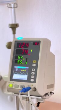 Medical monitor displaying patient vital signs and heart rate data inside hospital intensive care unit, healthcare technology concept for emergency treatment and clinical monitoring.