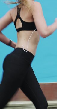 Running, earphones and fitness with woman in city for streaming service, health podcast and cardio. Wellness, exercise playlist and training music with person outdoor for audio, workout and radio