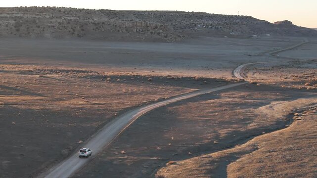 Aerial View of White SUV Vehicle Moving on Desert Road in Southwestern Colorado USA, Drone Shot