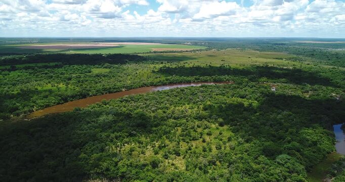 Wide cerrado river bend surrounded by gallery forest, wet pasture and agricultural frontier near Arinos, Minas Gerais, Brazil within the Urucuia Plateau and S&atilde;o Francisco basin. Drone forward and yaw