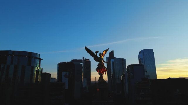 &Aacute;ngel de la Independencia al amanecer con skyline moderno de Ciudad de M&eacute;xico, toma a&eacute;rea con dron