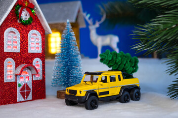 Obraz premium A yellow car near a red house with a blue Christmas tree nearby