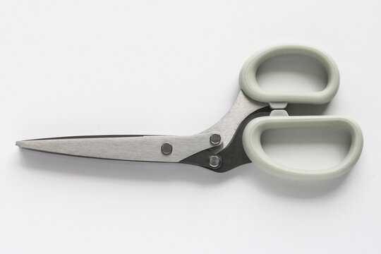Top view of stainless steel kitchen scissors with grey handles isolated on a white background.