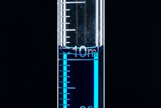 Macro shot of a graduated borosilicate pipette with deep cobalt blue liquid. Sharp volumetric markings and a perfect meniscus highlight scientific rigor and high-end laboratory aesthetics.