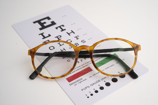 Glasses on eye testing exam chart to check eyesight accuracy of reading.