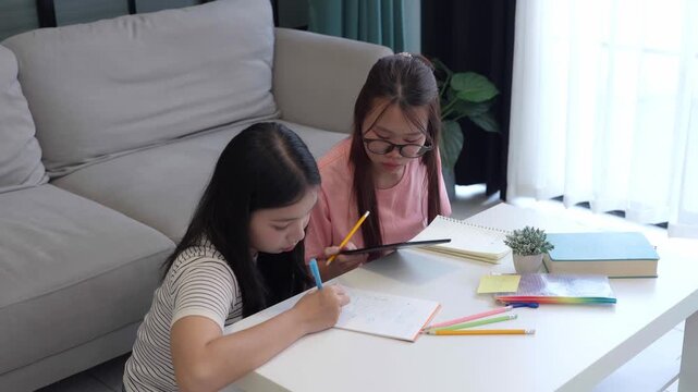 Two Asian girls using tablet search data for doing homework