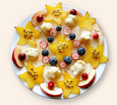 fruit plate with carambole, passionfruit seeds, cranberries and blueberries