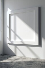 Fototapeta premium Blank White Modern Picture Frame on White Wall with Sunlight Shadows and Concrete Floor