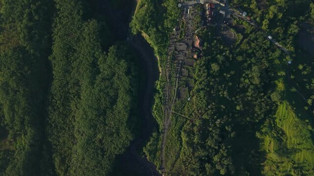 Aerial view of Bunker Kaliadem Merapi surrounded by lush green forests and a deep volcanic ravine in Kecamatan Pakem, Daerah Istimewa Yogya, Indonesia.