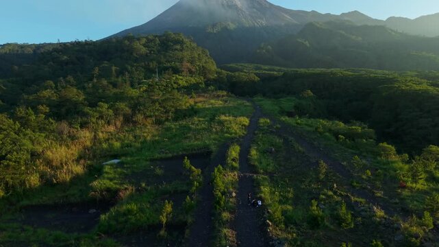 Aerial view of Bunker Kaliadem Merapi and Mount Merapi area with winding paths and lush green forest in Kecamatan Pakem, Daerah Istimewa Yogya, Indonesia.