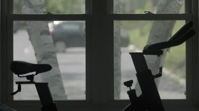 Indoor cycling workout equipment dark shadows against blurry street view