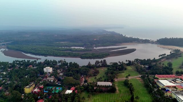 Aerial of Canacona highlighting Talpona river inlets and tropical vegetation, highlighting broad river channels, mangrove-covered islands, and textured sandbars blending into an expansive tropical h