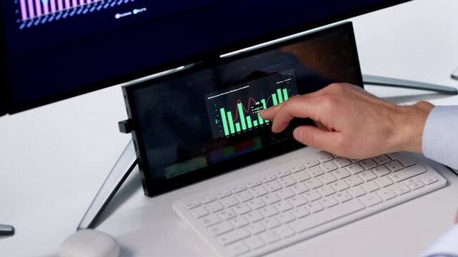 Man Studies Financial Data On Computer Monitor