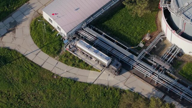 Aerial view of UGS Damborice facility with a tanker truck parked near industrial pipes and a large storage tank in Damborice, South Moravian Region, Czechia.