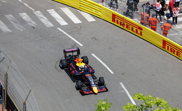 Monaco-Ville, Monaco on May 24, 2024. Overhead editorial view of an open-wheel Formula 1 racing car in classic Red Bull livery navigating a sharp corner on the historic Monte Carlo street circuit.