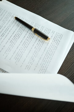Close up of prented pages of novel and pen placed on desk in home office 