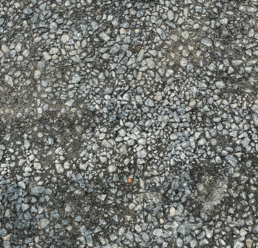 Grey crushed stone and gravel texture background, top view of rough aggregate surface.