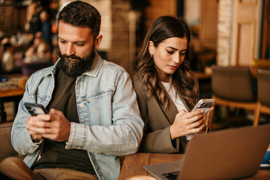 Couple phubbing while using smartphones in cafe