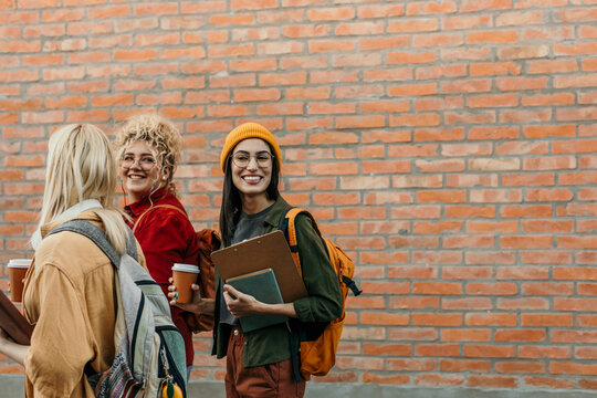 Happy young university students walking together on campus