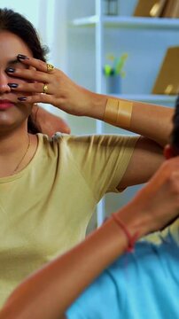 Indian family of four bhramari pranayama or bee breathing exercise practicing yogic breath together indoors during calm morning hours inside a modern home promoting health wellness in yogic style