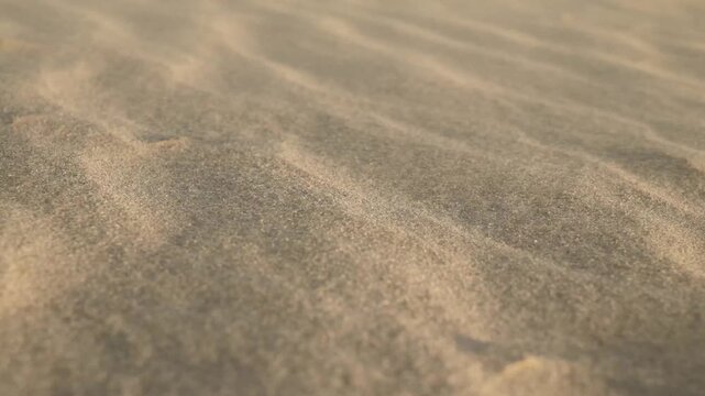 Close up of sand dunes with wind blowing creating rippled patterns in natural light.