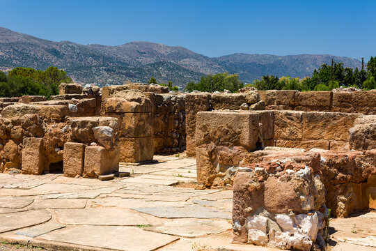 Remains of ancient stone structures at an archaeological site under blue sky