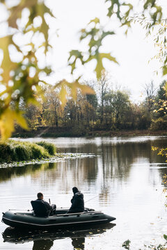 Two Fishermen Fishing From Boat River