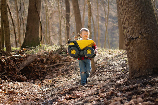 Toddler Carrying Toy Dump Truck Outdoors