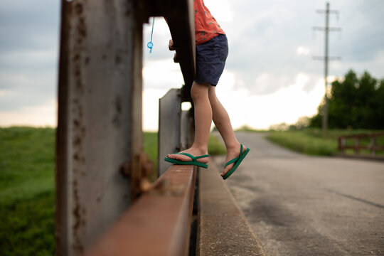 Child looking over rural bridge railing