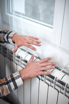 Man heating on a chilly winter day, energy and gas crisis, cold room, heating problems.