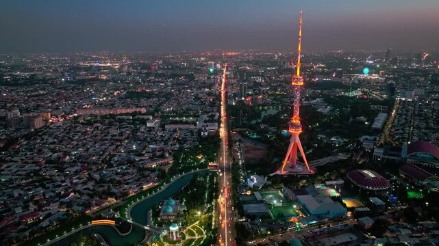 A drone over the evening streets of Tashkent against the backdrop of a sunset. View of the TV Tower