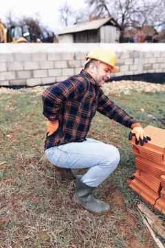 Construction worker having a accident and injured back on a construction site outdoors.