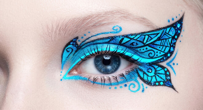 Creative eye makeup with blue butterfly wing pattern and intricate swirls macro