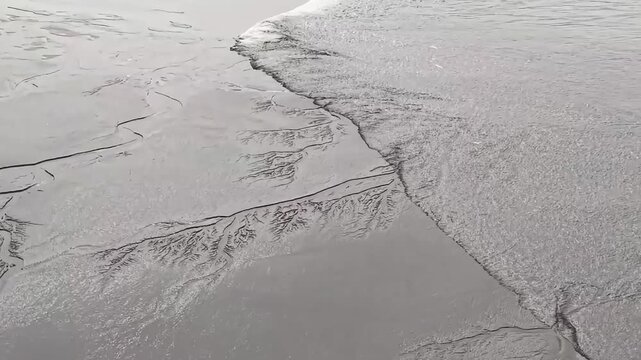 Stunning drone view capturing the "Tidal Tree" patterns and fish scale tide on a muddy beach in China. A unique natural masterpiece of water erosion and tidal force.