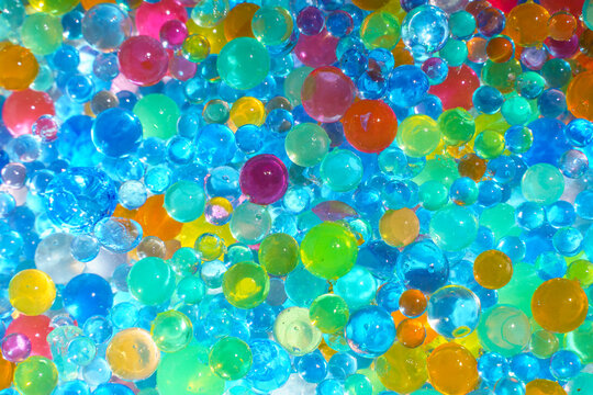 Colorful transparent water beads background with vibrant gel spheres texture