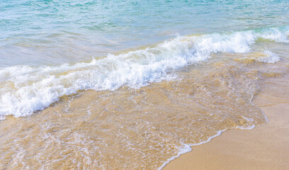 Gentle ocean waves lapping against sandy beach shoreline in sunlight © SeNata