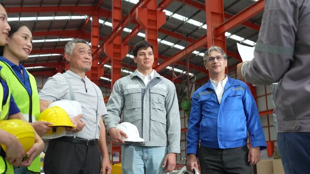 A team of engineers and staff are inspecting the production line system at a metal sheet and roofing factory. (4K video)