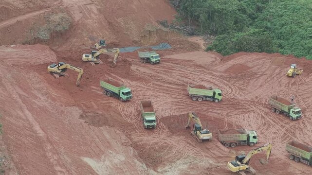 Aerial view of loading and unloading activities of trucks and excavators for highway construction