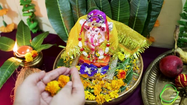 woman performing ganesha worship ritual at home temple on ganesh chaturthi festival