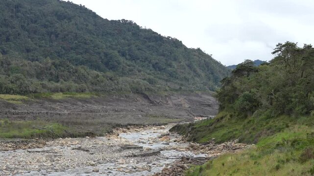 Scenic landscape of dry river bed surrounded by mountains in Chingaza paramo during dry season in Colombia