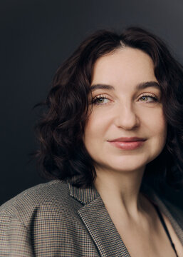 A studio portrait of a beautiful girl with curly hair and a lovely smile 