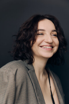 A studio portrait of a beautiful girl with curly hair and a lovely smile 
