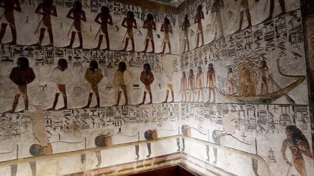Close-up of ancient Egyptian relief carving inside KV17 tomb of Seti I, Valley of the Kings, Luxor, Egypt, showing a deity figure with black hair and deteriorating pigment.